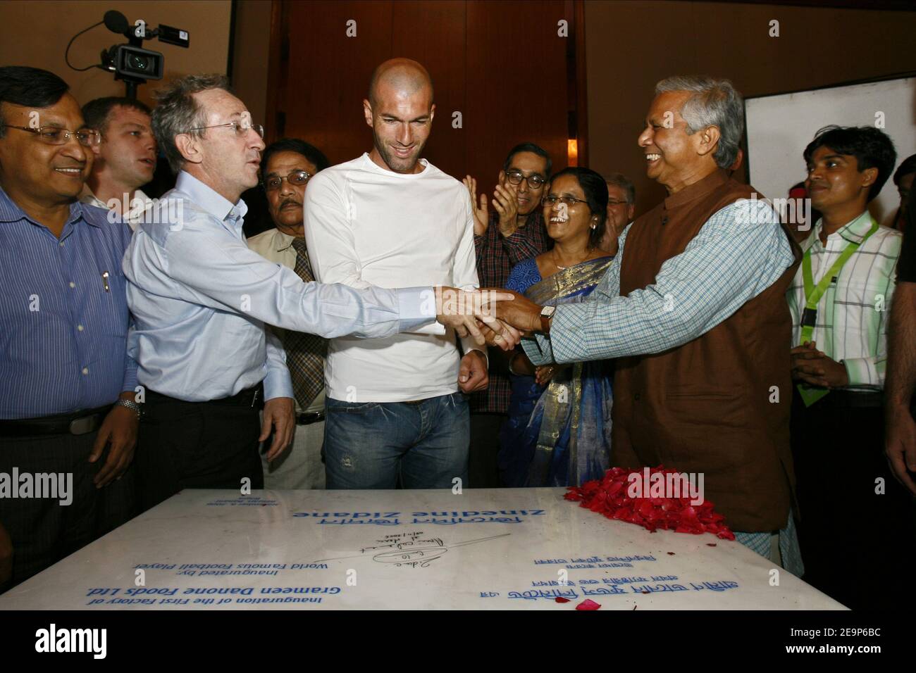 French football player Zinedine Zidane signs his autograph with Danone CEO Franck Riboud and Bangladeshi Nobel Peace Prize winner Muhammad Yunus on a stone as he officially opens a yogurt factory project run by French food giant Danone and Grameen Bank at a ceremony in Dhaka, Bangladesh on November 8, 2006. The project set up in the northern Bangladesh town of Bogra will produce nutritious food products for the people in the low income area. Photo by Patrick Durand/Cameleon/ABACAPRESS.COM Stock Photo