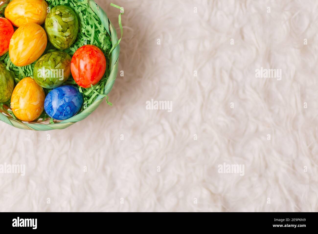 Easter card. Flat lay composition with easter eggs in a basket on white ...