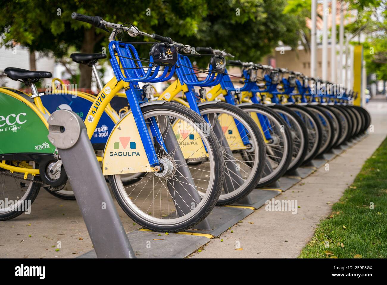 Las Palmas, Spain - August 8, 2020. Group of many public city bicycles parked in rack row. Smart eco friendly transport Stock Photo