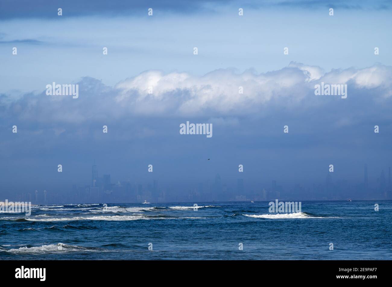 NYC skyline as seen through clouds from Sandy Hook Beach, NJ Stock