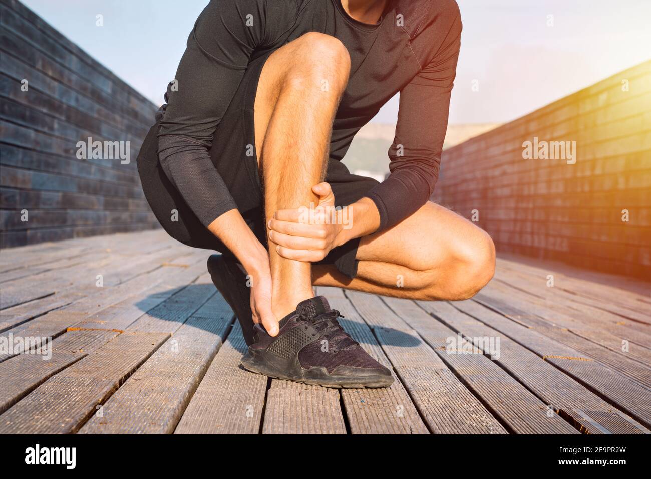 Runner suffering from ankle pain or achilles injury. Ankle twist sprain accident Stock Photo