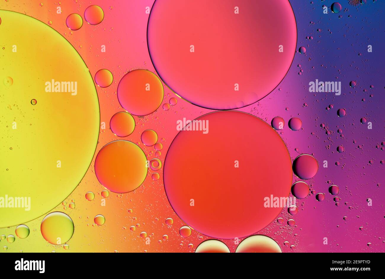 Olive oil drops suspended in water with colorful backgrounds Stock