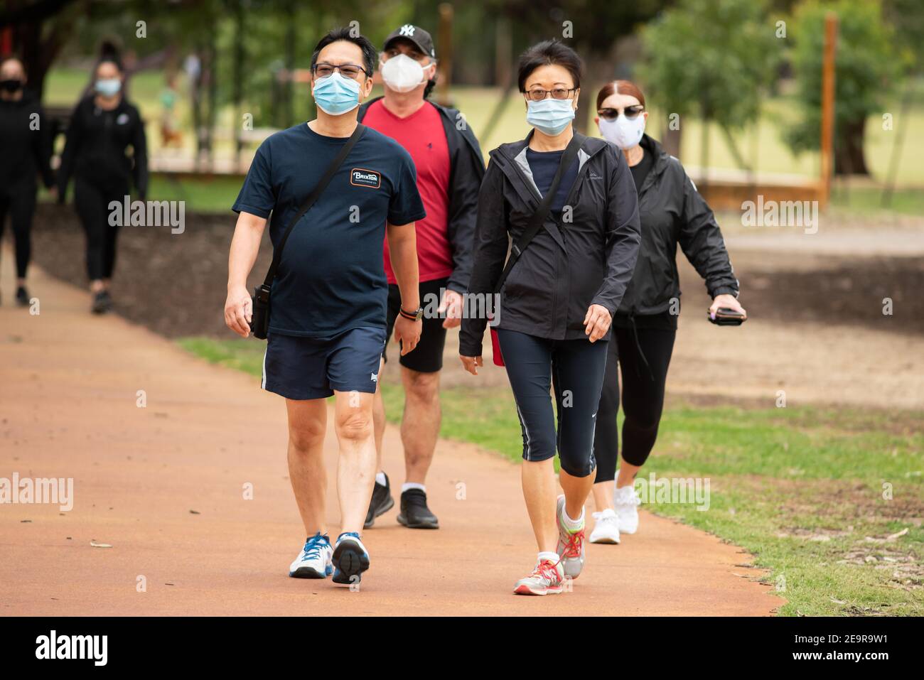 Group of people walking while wearing masks on the first day following