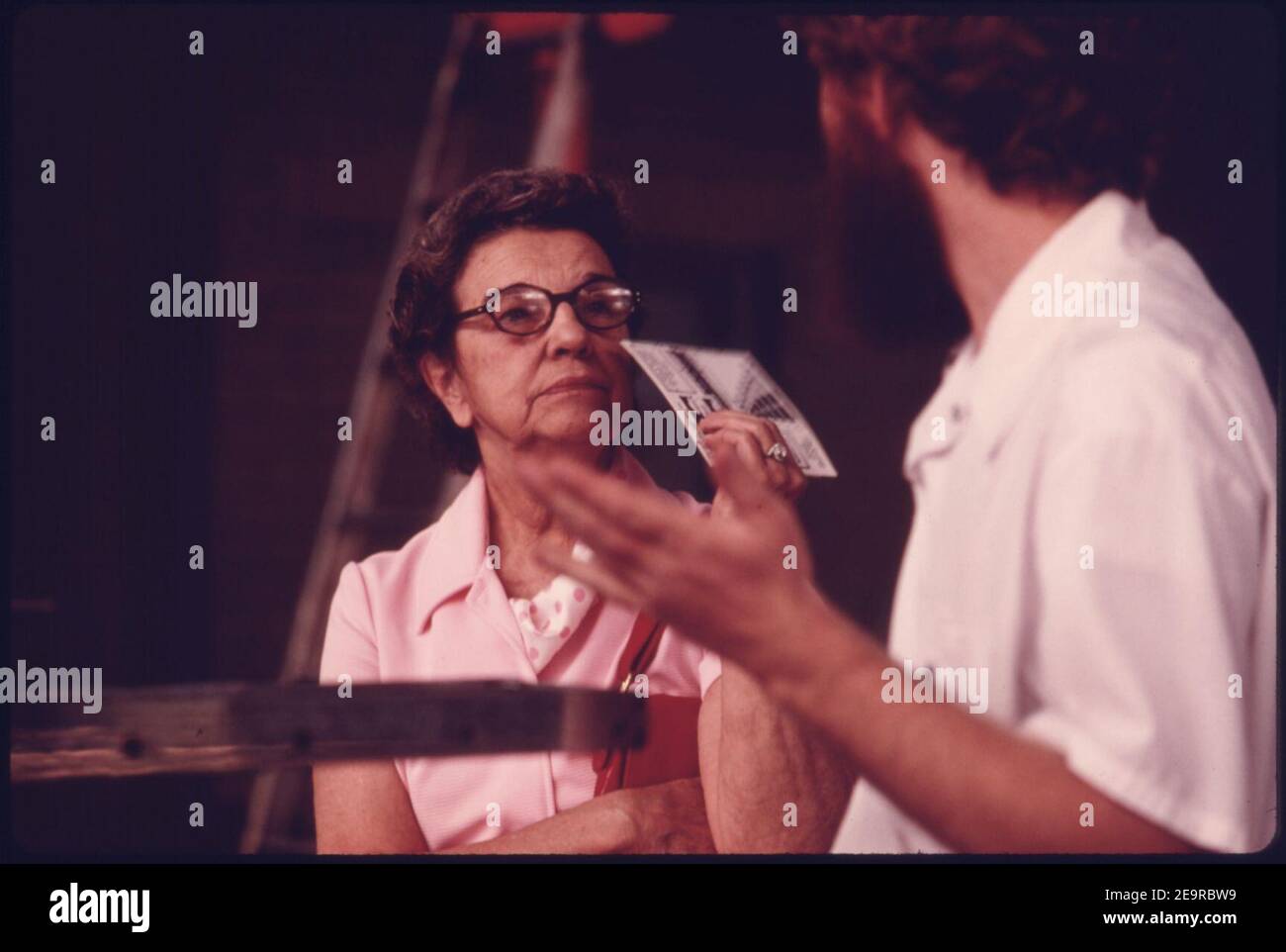 Motorist, Left, Listens to a City Employee Explain the Exhaust Emissions Test at an Auto