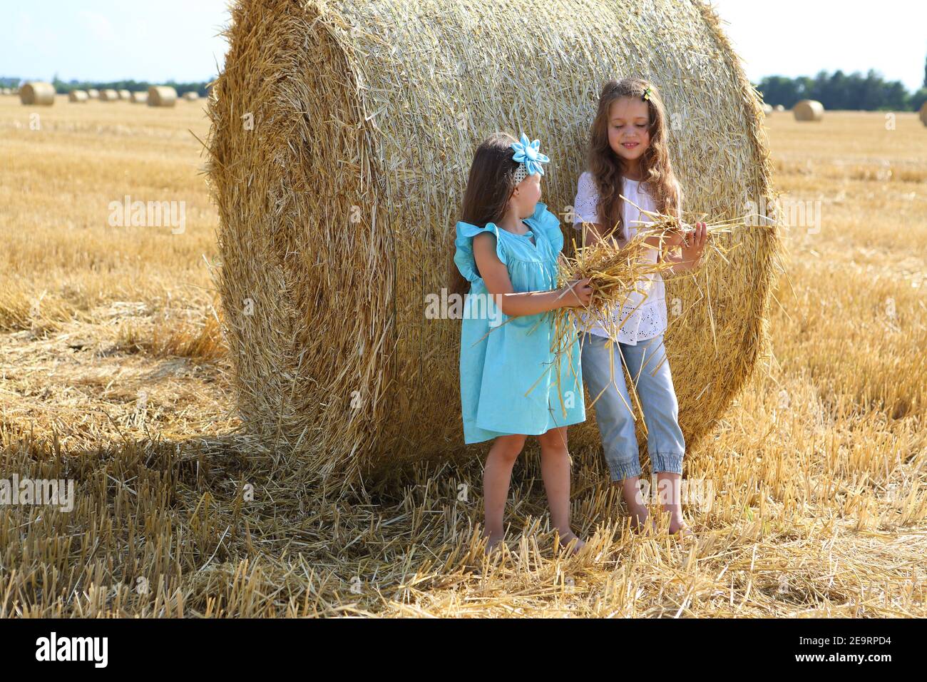 Two little girls playing in a wheat field Stock Photo - Alamy