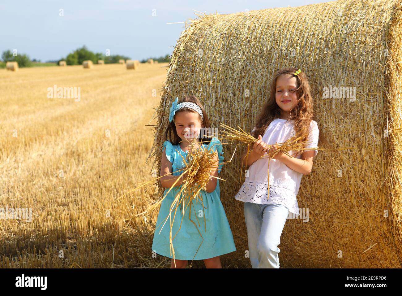 Two little girls playing in a wheat field Stock Photo - Alamy