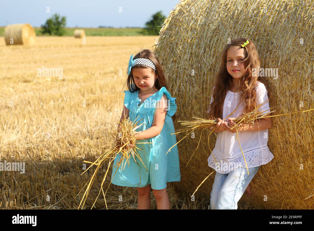 Two little girls playing in a wheat field Stock Photo - Alamy