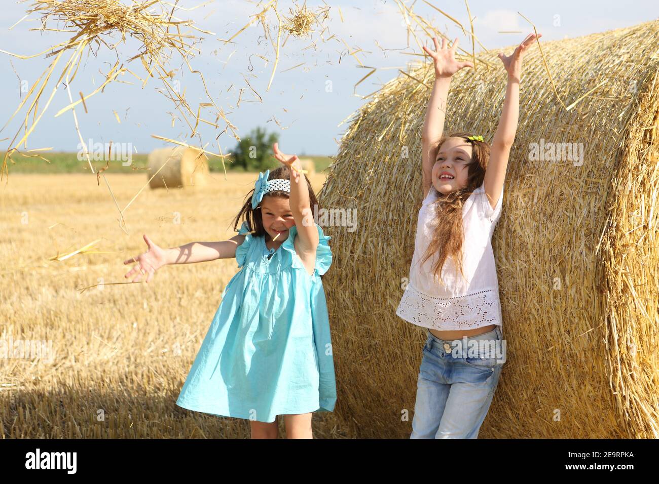 Two little girls playing in a wheat field Stock Photo - Alamy