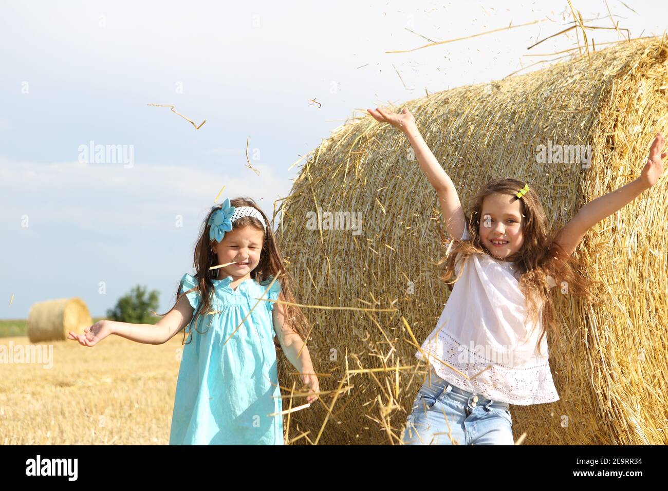 Two little girls playing in a wheat field Stock Photo - Alamy