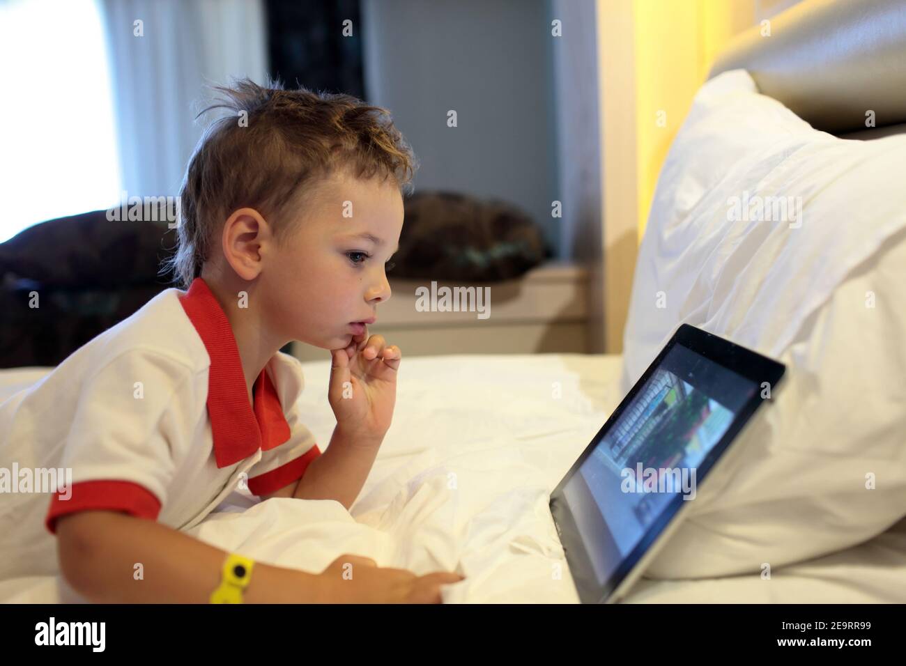 Boy lying on the bed with the tablet PC at home Stock Photo - Alamy