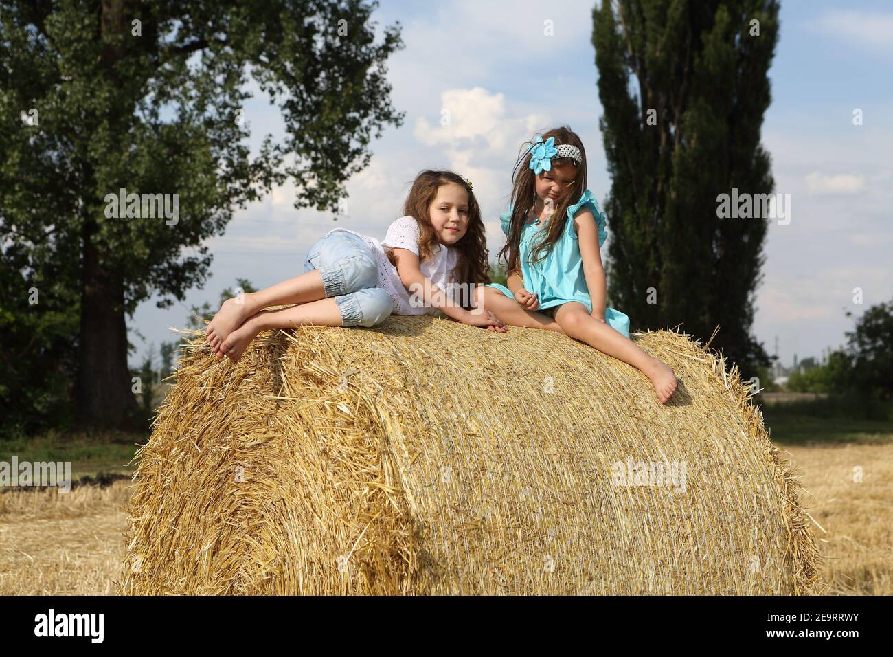 Two little girls playing in a wheat field Stock Photo - Alamy