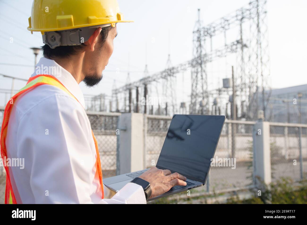 Engineer hold laptop computer inspection on site power plant high volte system Stock Photo
