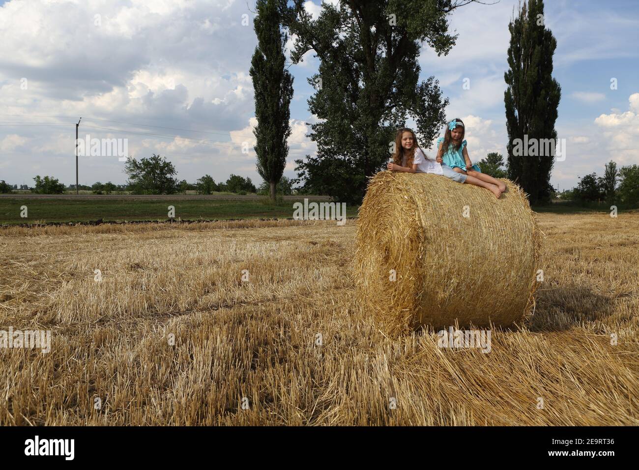 Two little girls playing in a wheat field Stock Photo - Alamy