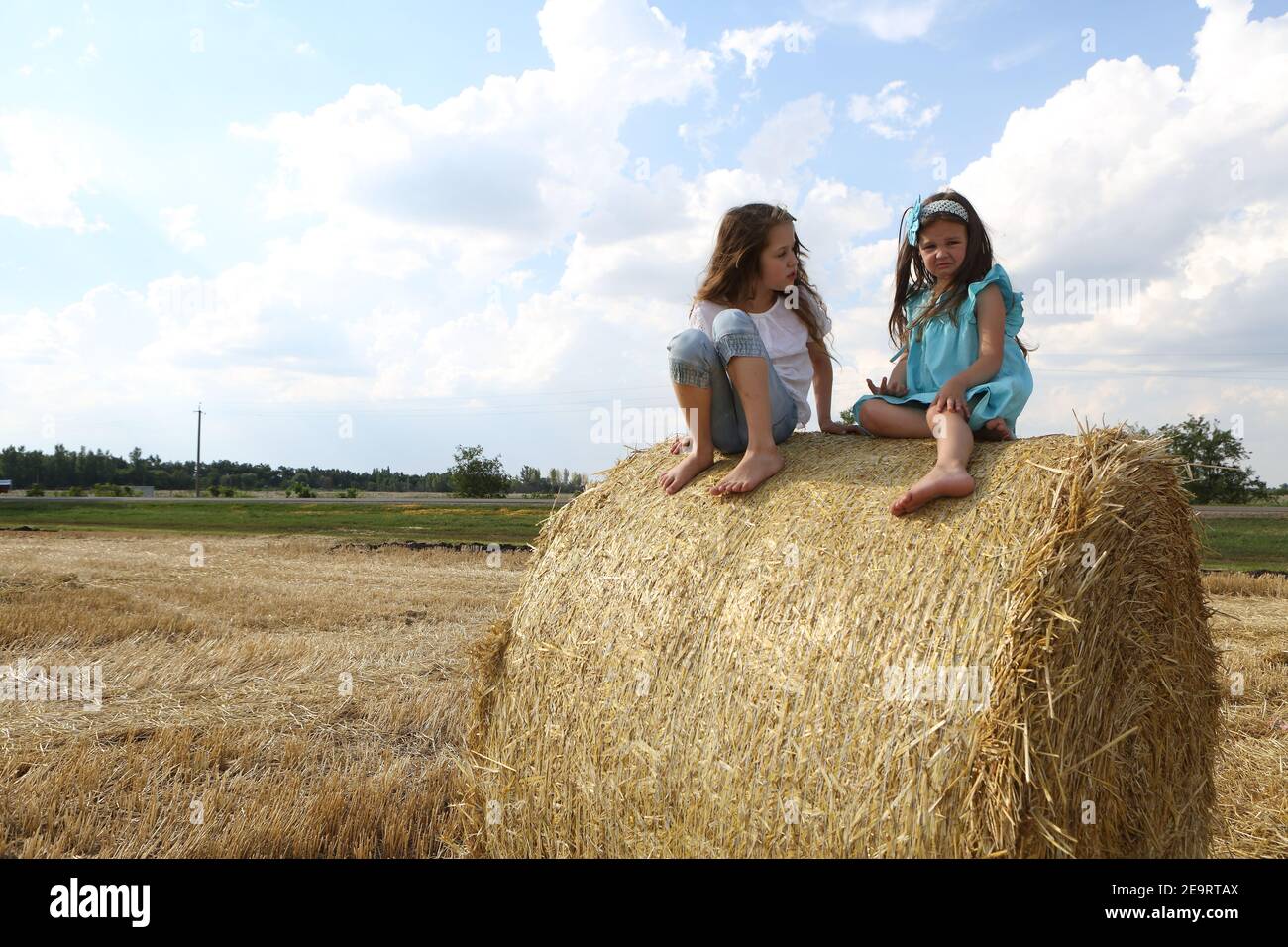 Two little girls playing in a wheat field Stock Photo - Alamy