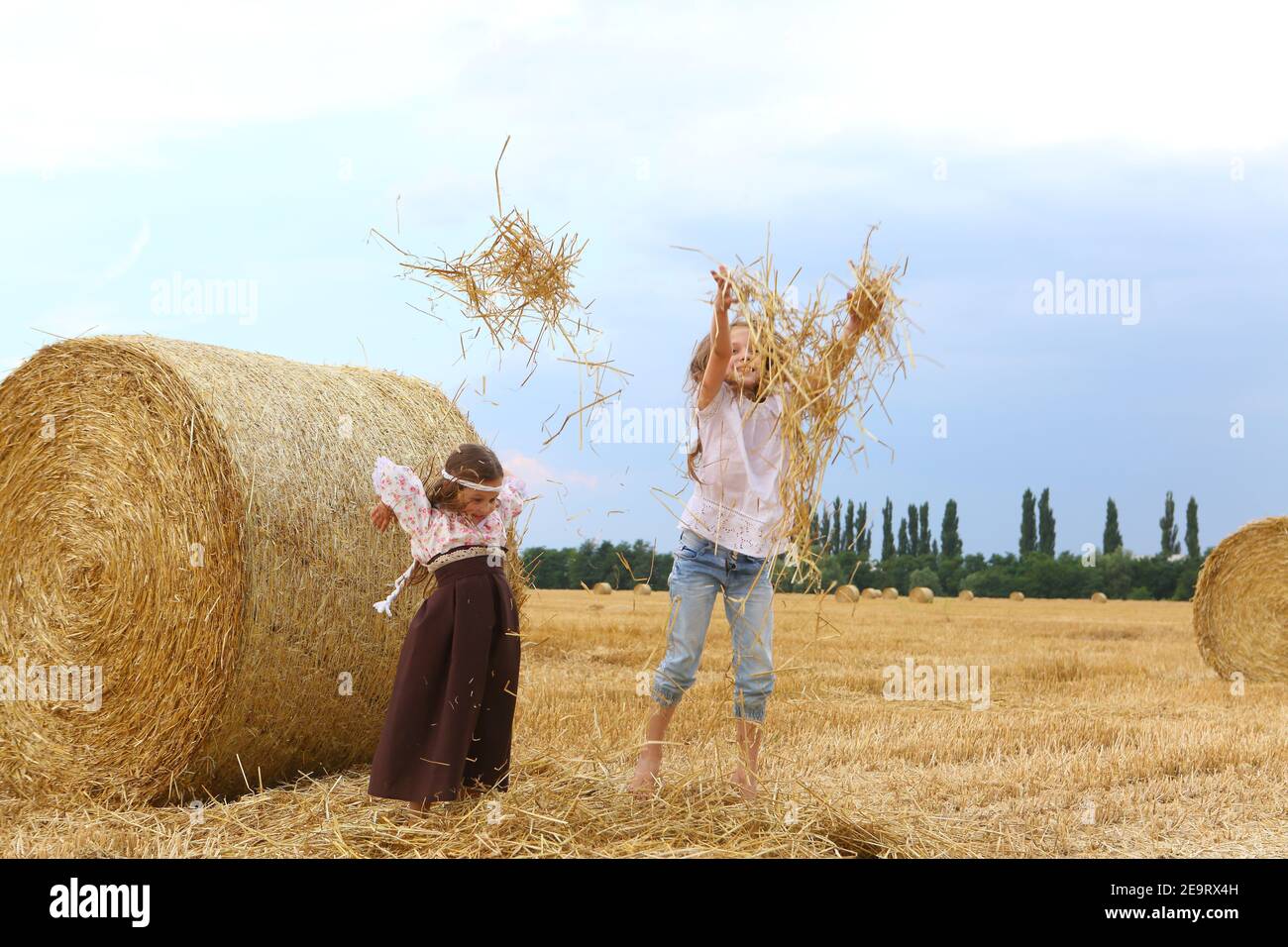 Two little girls playing in a wheat field Stock Photo - Alamy