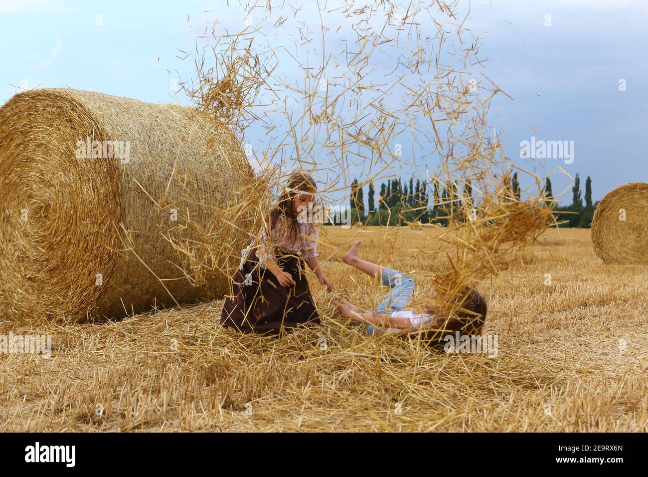 Two little girls playing in a wheat field Stock Photo - Alamy