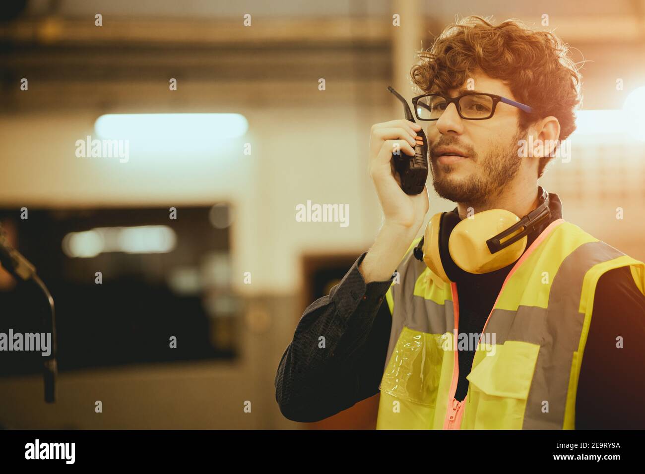 Young worker man using radio control communication in factory Stock Photo