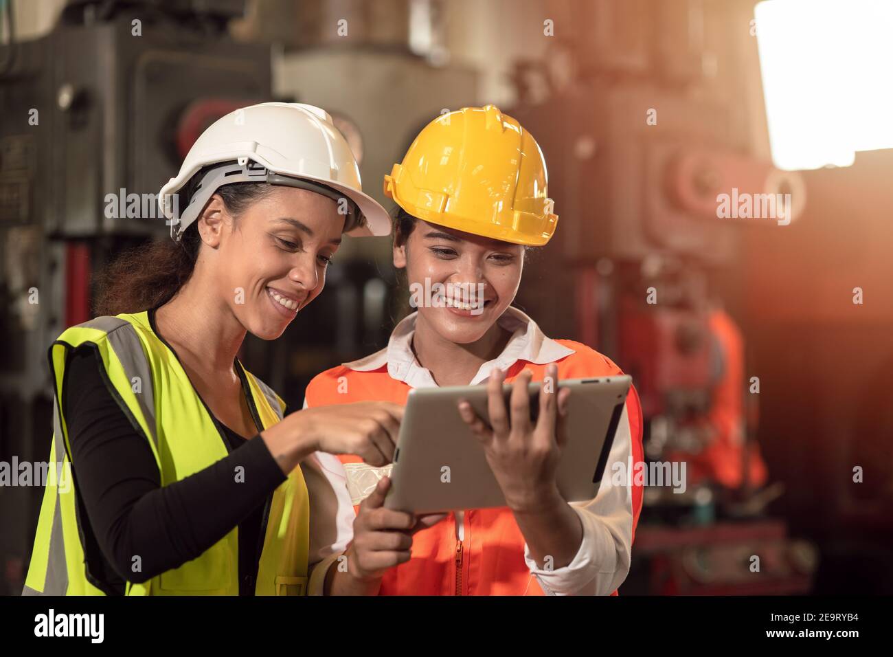 Women in factory engineer mix race working together using tablet happy smile Stock Photo