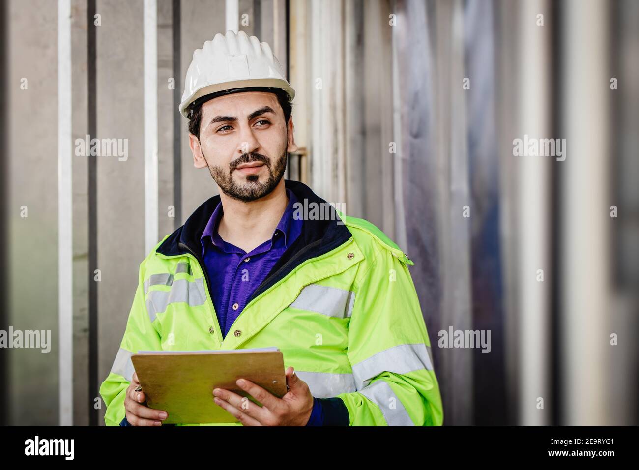 Handsome Latin Indian race worker working in industrial factory load warehouse hand holding check list looking smart Stock Photo