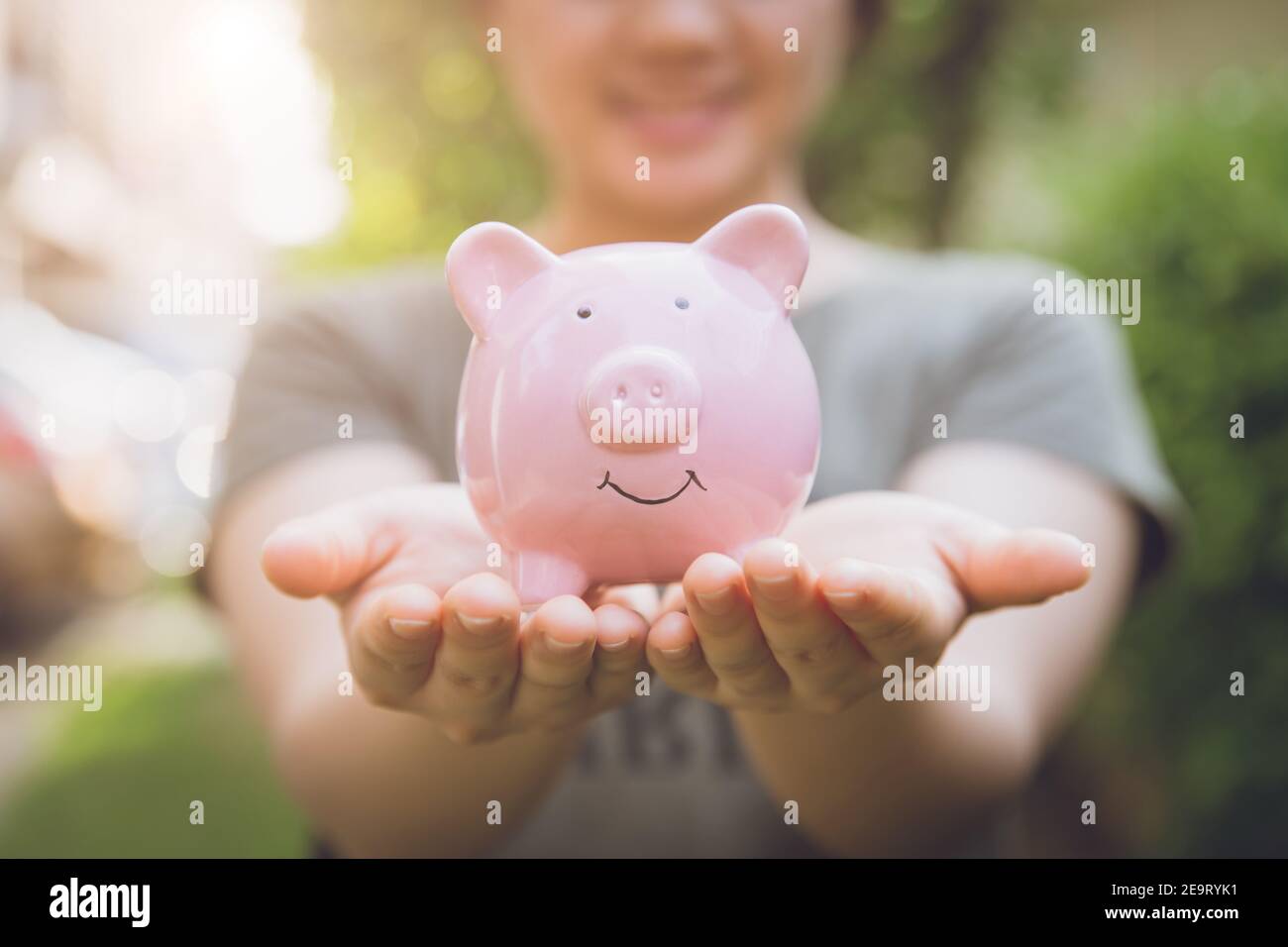 closeup happy smile money saving piggy bank  on girl hand. Stock Photo