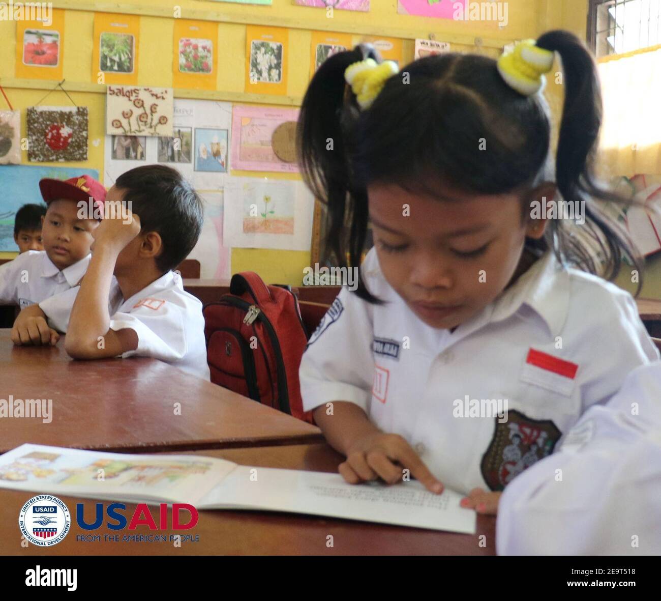 Murid di Sumatra Utara dengan mudah membaca buku bergambar yang dirancang untuk membantu meningkatkan pemahaman membaca di antara murid-murid kelas 1-3 SD (34427469930). Stock Photo