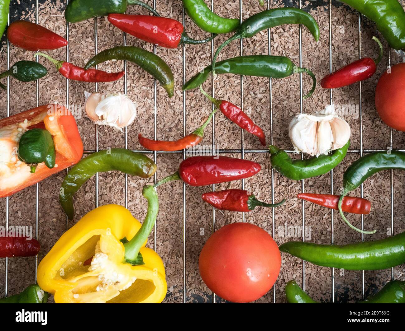 The holy trinity of capcicum bell pepper onion tomato garlic and chilli peppers over a grill