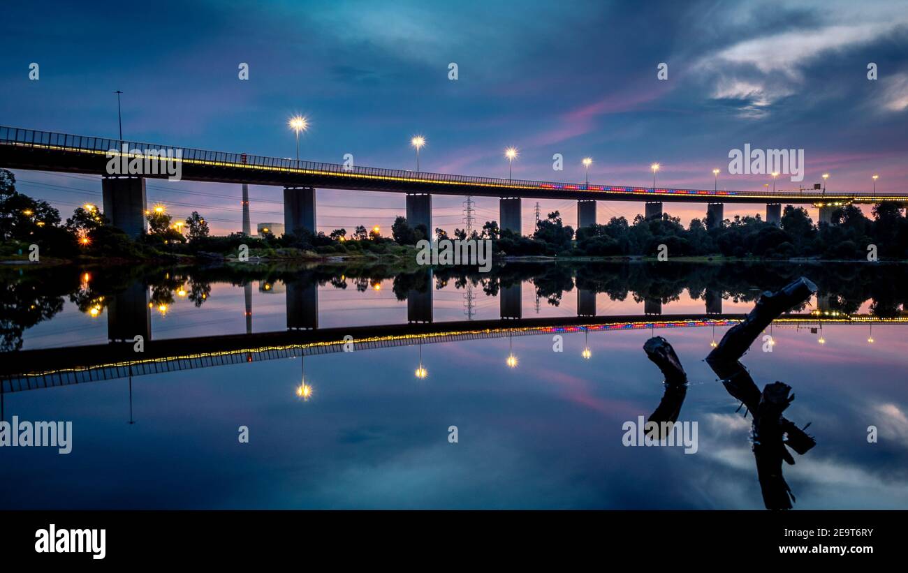 The reflections of the melbourne city skyline at dusk in the still water of the west gate bridge Stock Photo