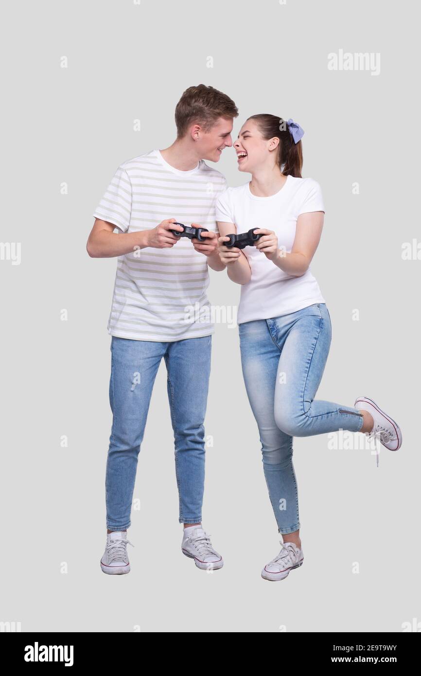 Couple Standing with Joysticks in Hands Looking at Each Other Smilling Isolated Stock Photo