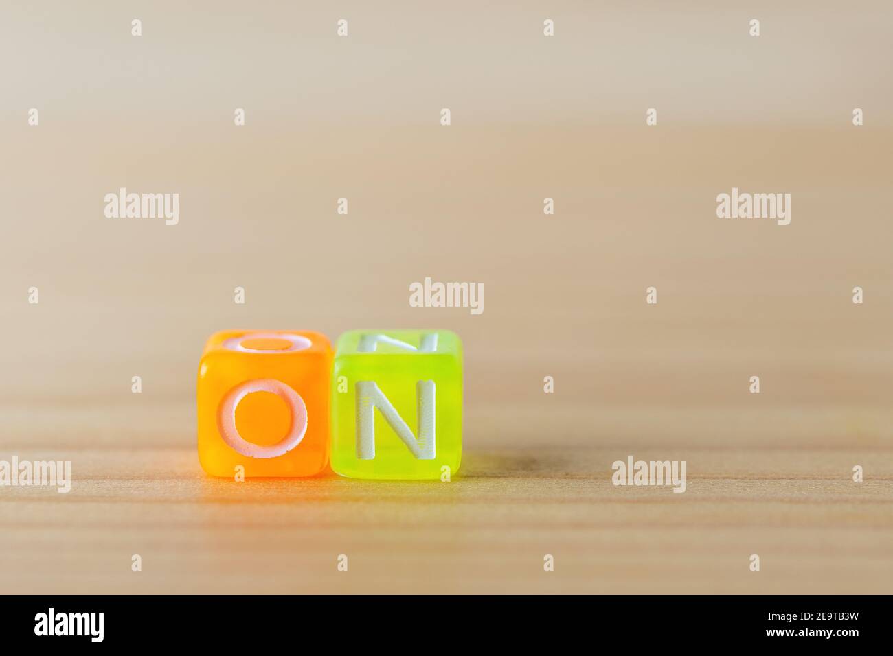 ON text with color letters cubes on wooden background. Minimal concept. Stock Photo