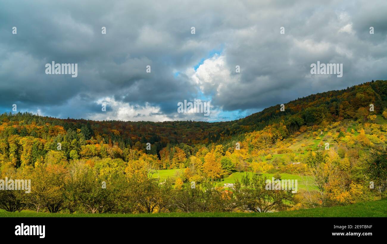Germany, Beautiful colorful autumn mood in nature landscape of swabian forest near rudersberg with sun and shadows moving above the trees Stock Photo