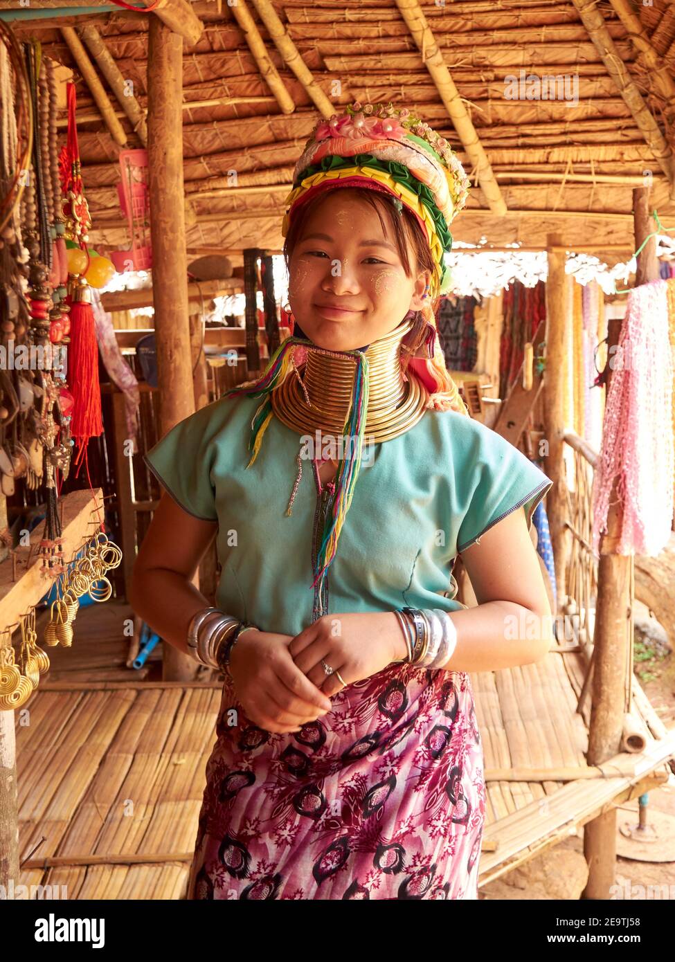 A beautiful smiling Karen hill tribe woman posing in their signature clothes and a unique necklace around her long neck Stock Photo