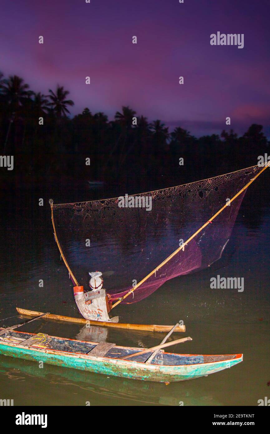 A local fisherman on the Ubod River casting his net at dusk, Donsol, Sorsogon Province, Luzon, Philippines. Stock Photo