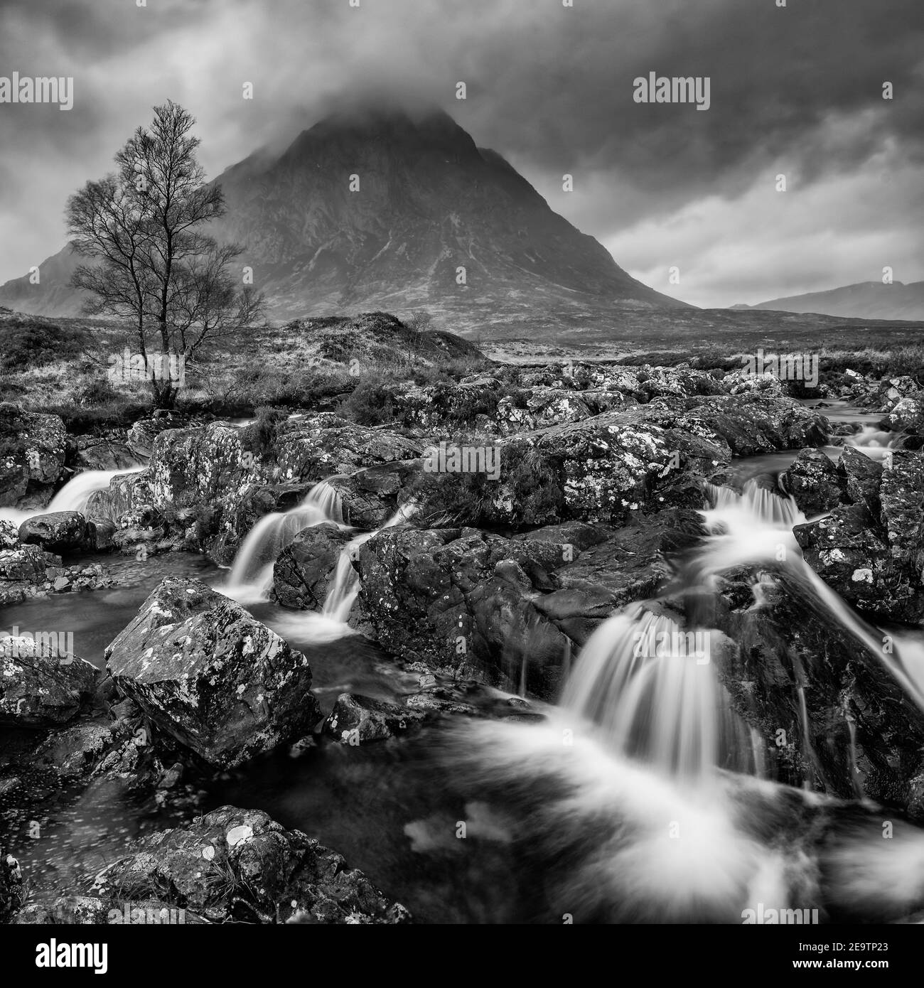 Stunning  black and white landscape image of Buachaille Etive Mor waterfall in Scottish highlands on a Winter morning with long exposure for smooth fl Stock Photo
