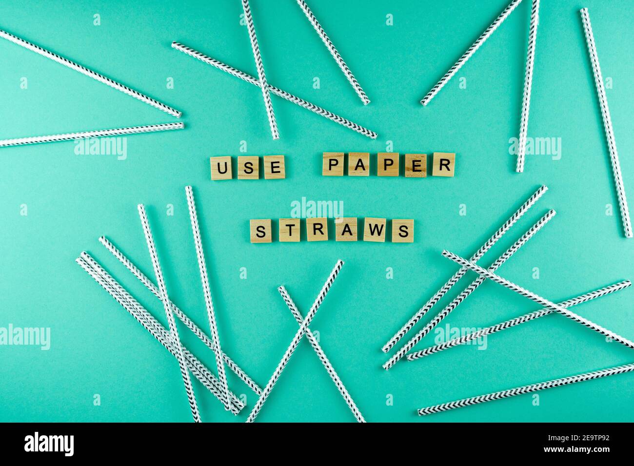 Use paper straws. Words laid out from wooden letters into a phrase. Paper straw for cocktails. Top view. Zero waste, environmental protection from pla Stock Photo