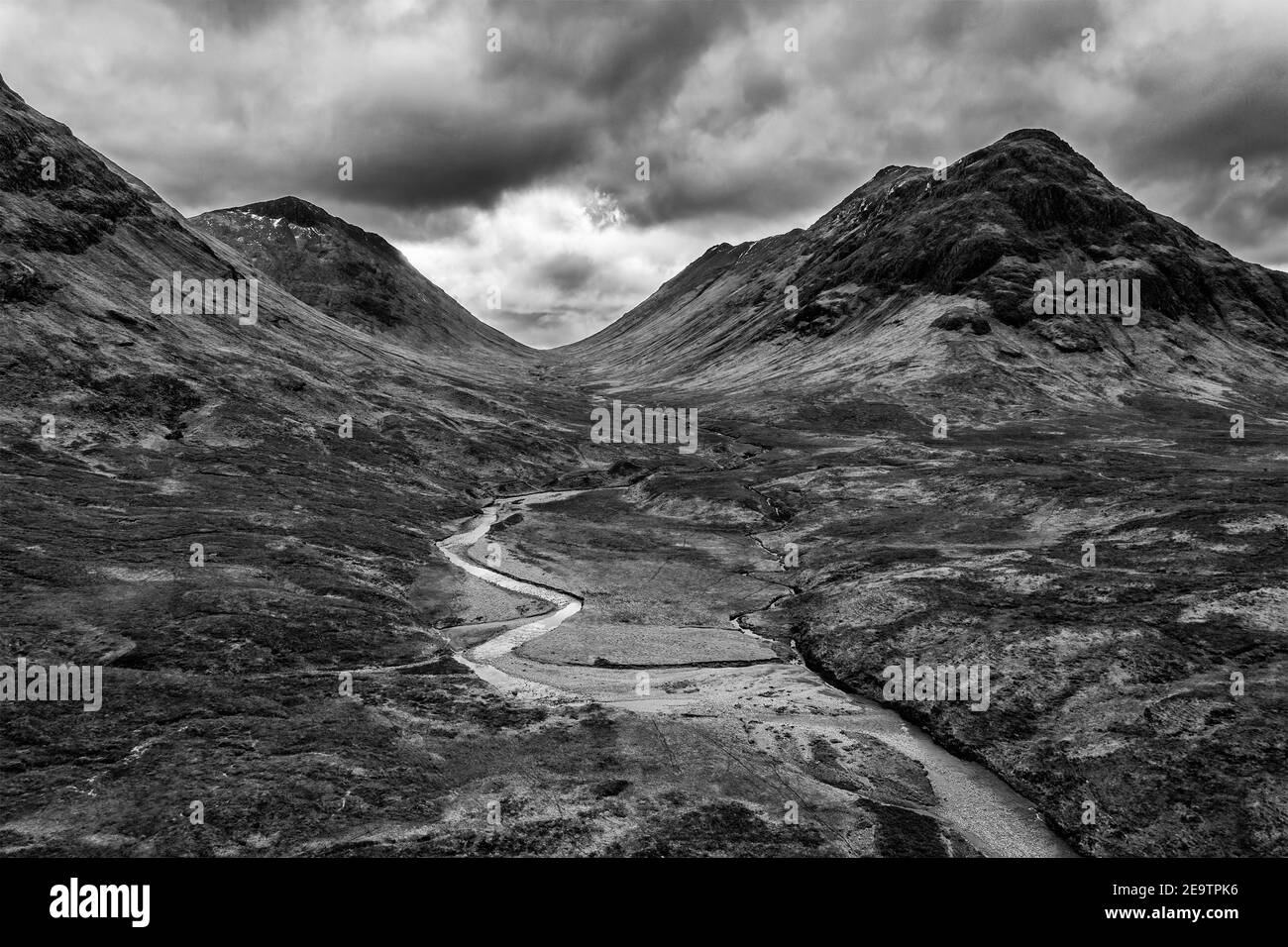 Flying drone dramatic  black and white landscape image of mountains rivers and valleys in Glencoe in Scottish Highlands on a Winter day Stock Photo