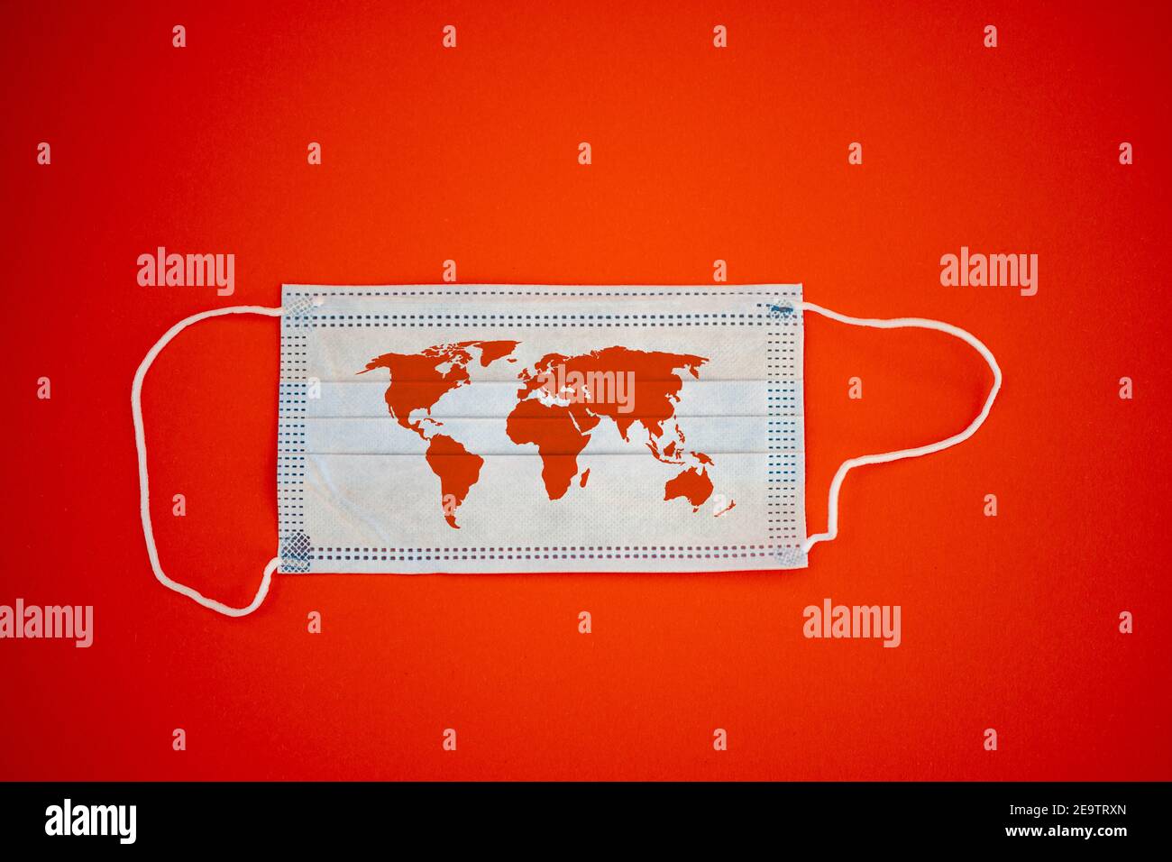 Medical face mask with the world map on a red background - global ...