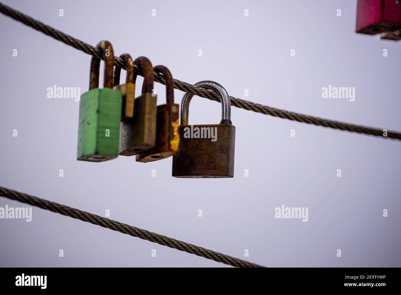 Some rusty padlocks on a steel cable as a symbol of  eternal love - This padlock is a classic couple  tradition (lovelock) Stock Photo