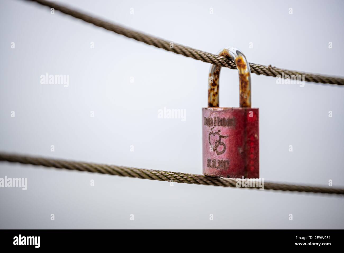 Some rusty padlocks on a steel cable as a symbol of  eternal love - This padlock is a classic couple  tradition (lovelock) Stock Photo