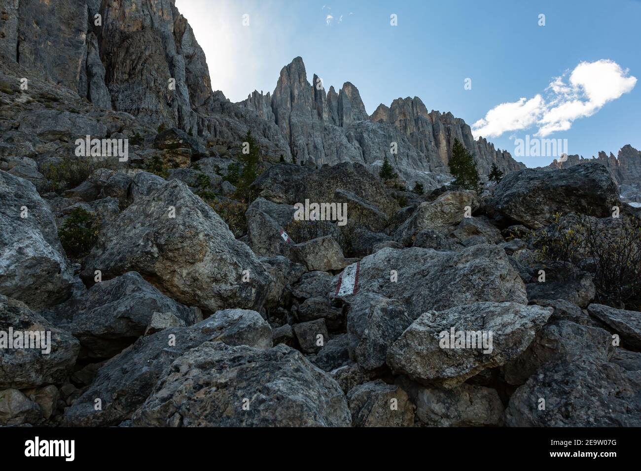 Alpine hiking path Hirzelweg crossing a boulder field with way markers, South Tyrolean Dolomites, Italy Stock Photo