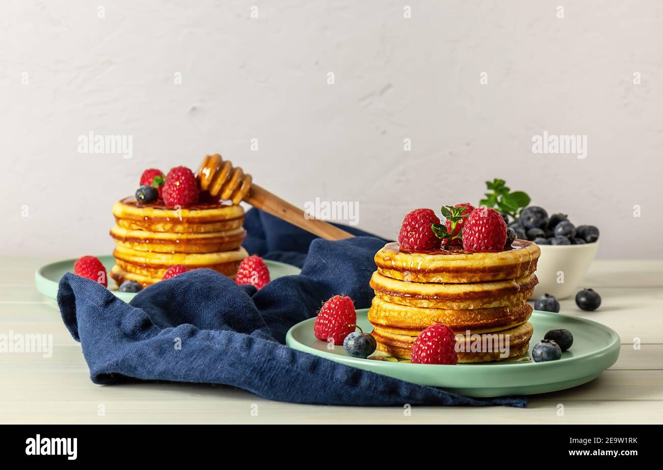 Tasty american pancakes with raspberries, blueberries, and honey Stock ...