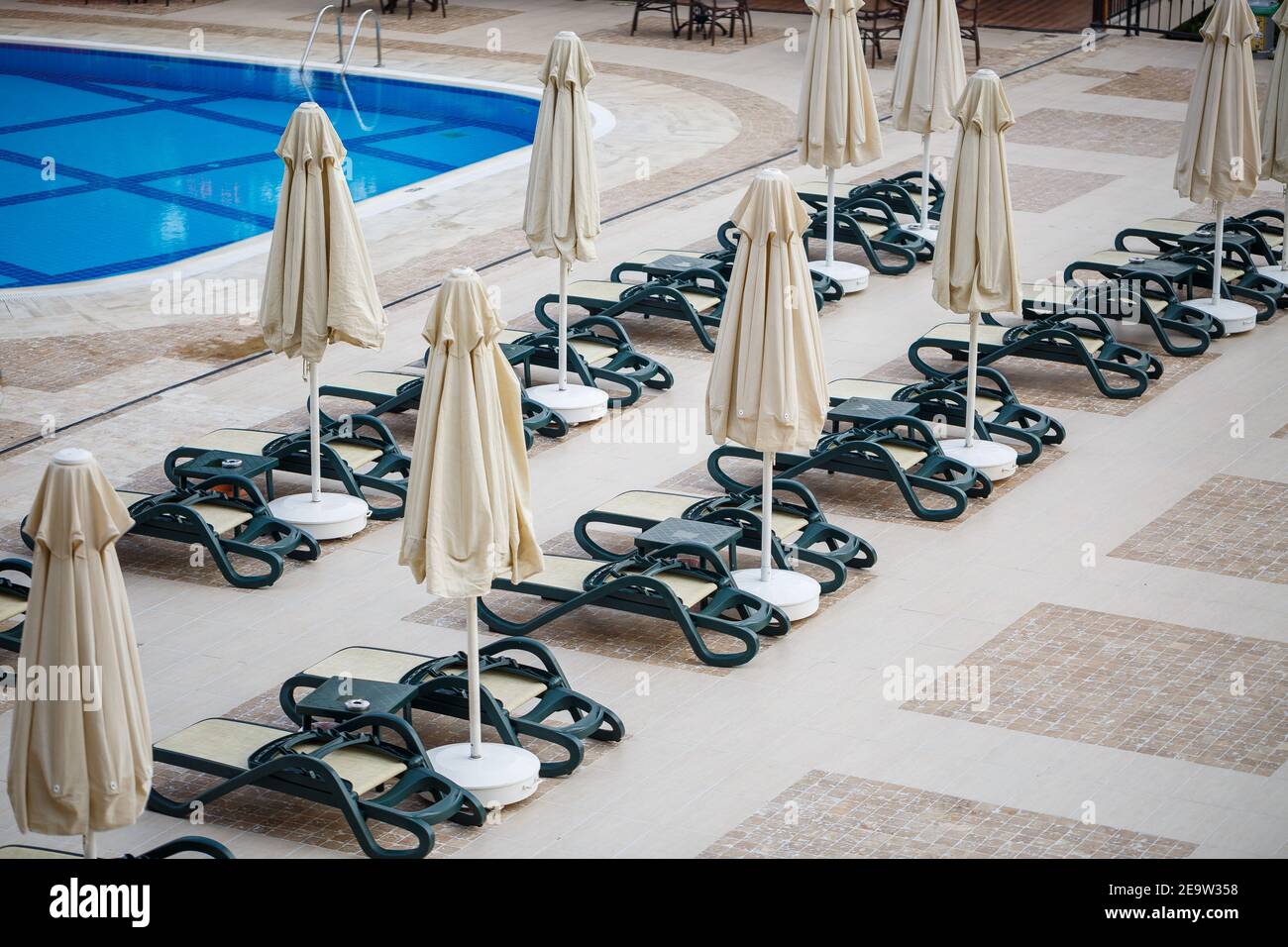 Plastic sun loungers and parasols for sun protection are placed on the