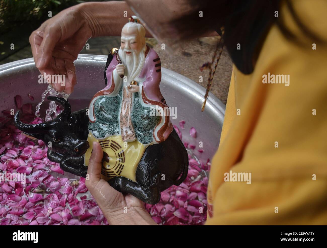 February 5, 2021, Malang, east java, Indonesia: A devotee clean statues of gods with the flower water ahead of the 2021 Chinese New Year celebrations or the entry of the Chinese zodiac metal buffalo in Chinese cultural beliefs at a temple in Malang, East Java, Indonesia, on February 6, 2021. Countries around Southeast Asia are set to welcome a subdued Lunar New Year with celebration curtail due to the Covid-19 Coronavirus pandemic.Indonesia is the largest Muslim country in the world. which has hundreds of tribes, cultures, and 6 religions that are protected by state law. Live in harmony in an  Stock Photo