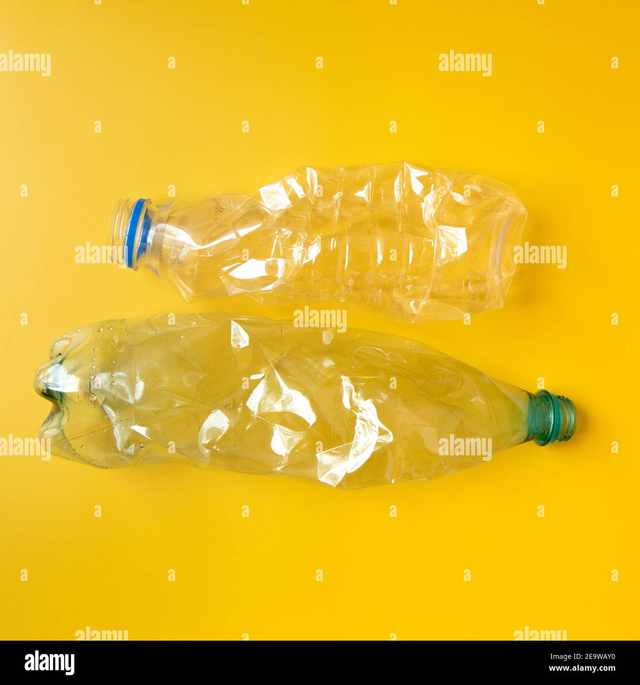 Used plastic bottles on yellow background. Stock Photo