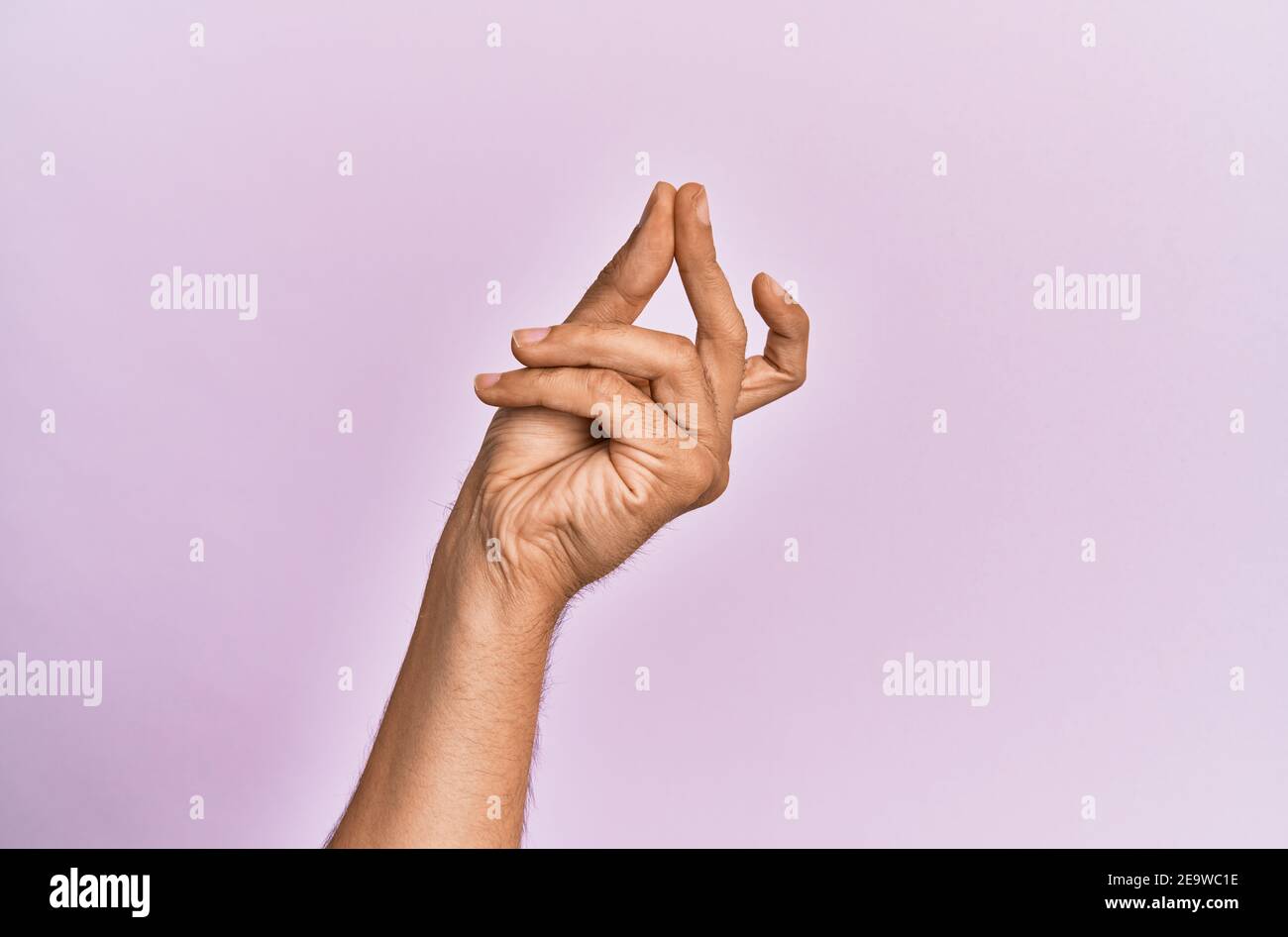 Arm and hand of caucasian young man over pink isolated background snapping fingers for success, easy and click symbol gesture with hand Stock Photo