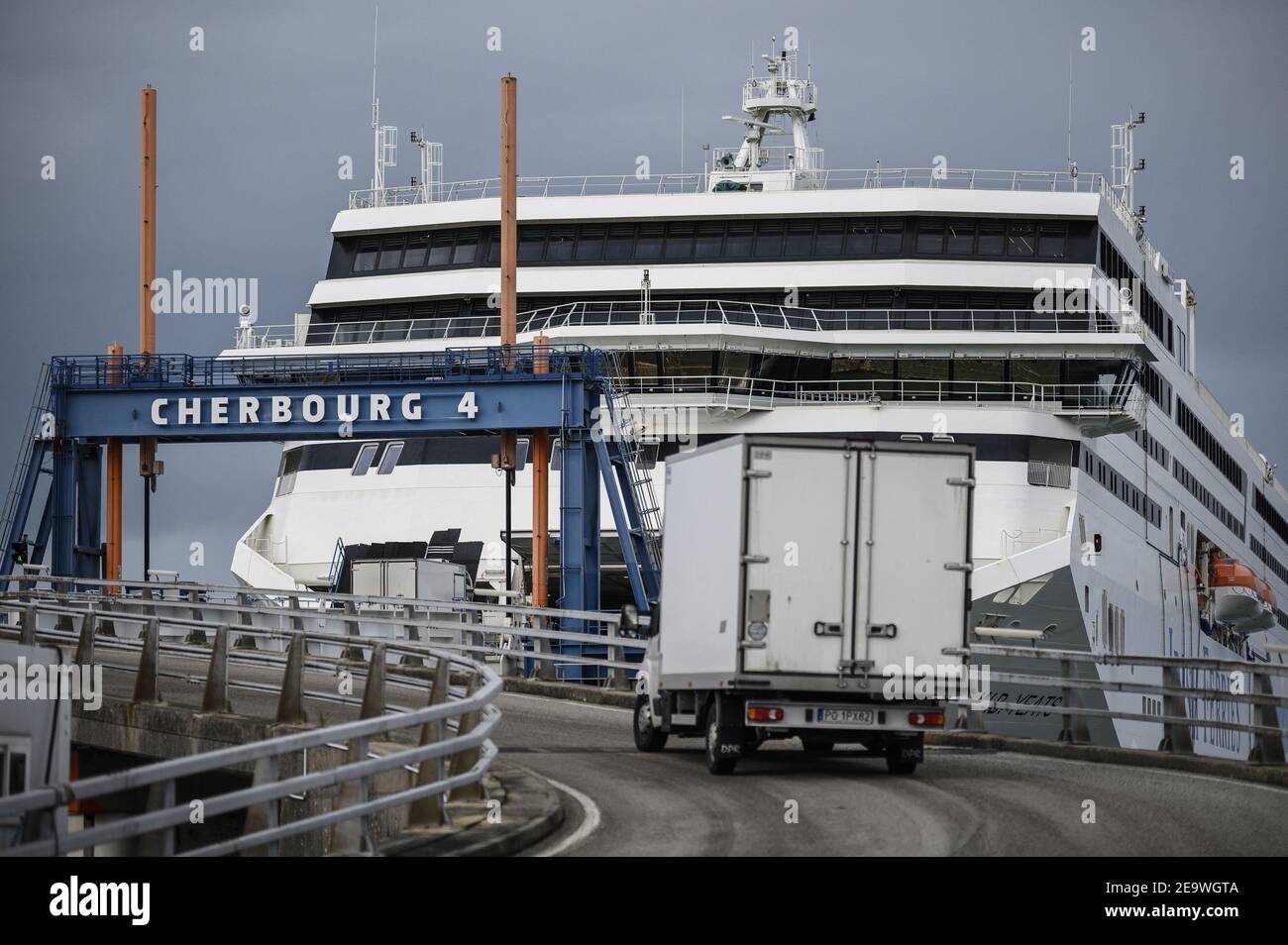 Employees of the port of Cherbourg prepare to load trucks on a ferry operated by Irish Ferries