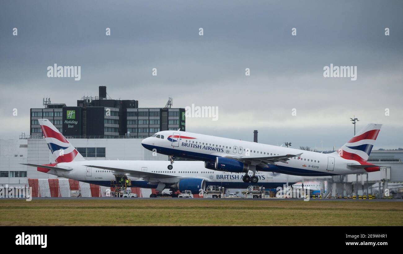 Glasgow, Scotland, UK. 6th Feb, 2021. Pictured: (background) A special cargo flight: a British Airways Boeing 777-236ER (reg G-YMMS) which arrived from Bangkok Flt no BA3580 last night carrying supplies of PPE into Glasgow, and is now being loaded back up with more cargo before departing for London Heathrow. A rare sight at Glasgow Airport but especially during the coronavirus (COVID19) pandemic where passenger numbers have fallen dramatically and a number of airlines have either gone bust or are taking a brief hiatus in order to save cash. Credit: Colin Fisher/Alamy Live News Stock Photo