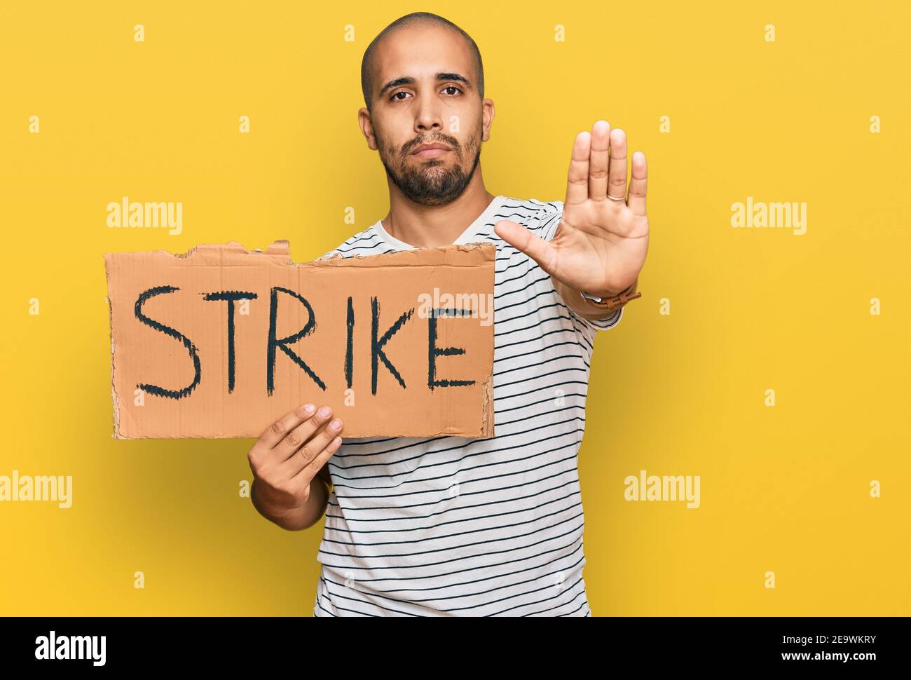 Strike Sign Man Hispanic adult man holding strike banner cardboard with open hand doing ...