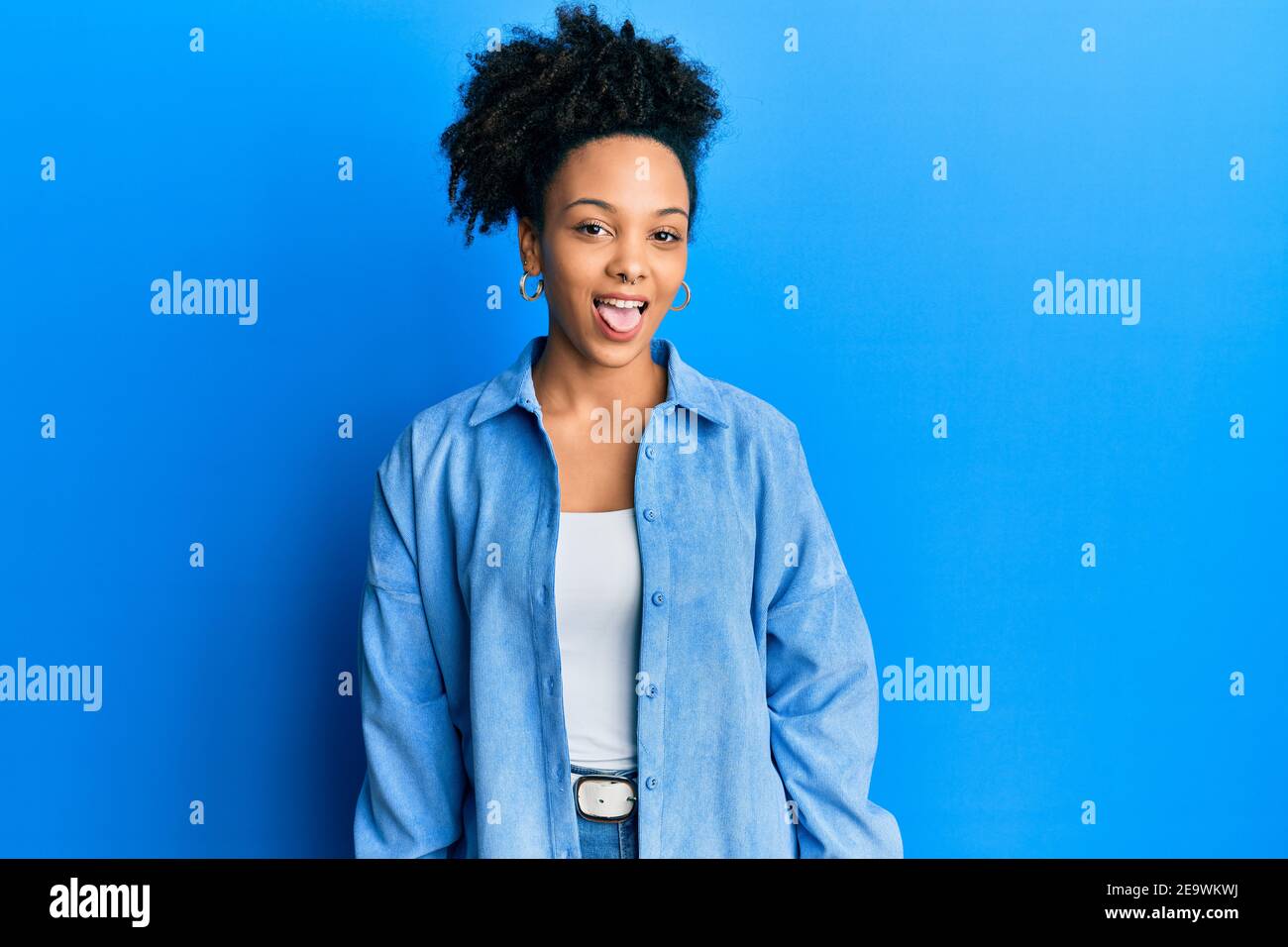 Young african american girl wearing casual clothes sticking tongue out ...