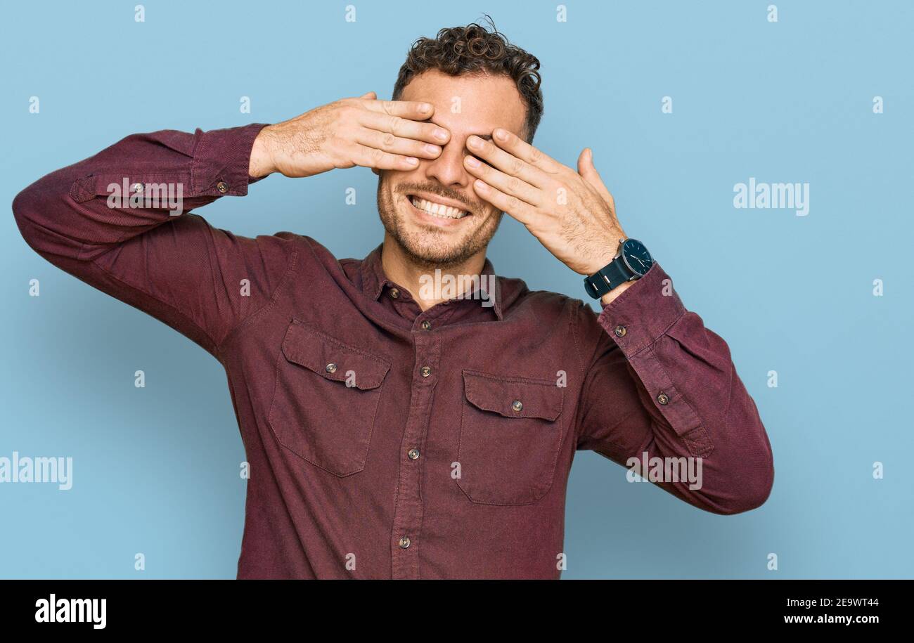 Young hispanic man wearing casual clothes covering eyes with hands ...