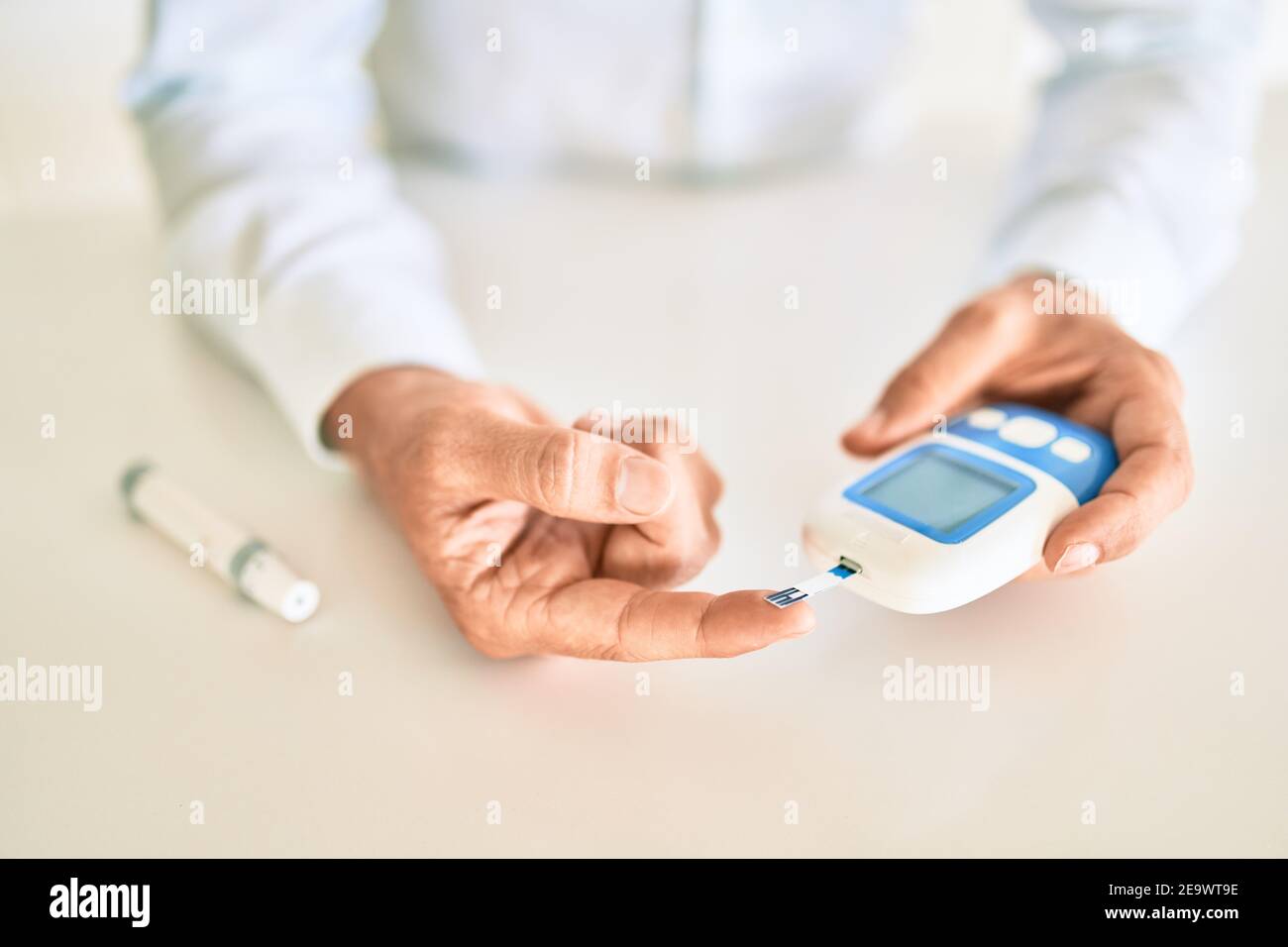 Man Using Glucometer Close up of man with diabetes using insuline glucometer with blood from ...